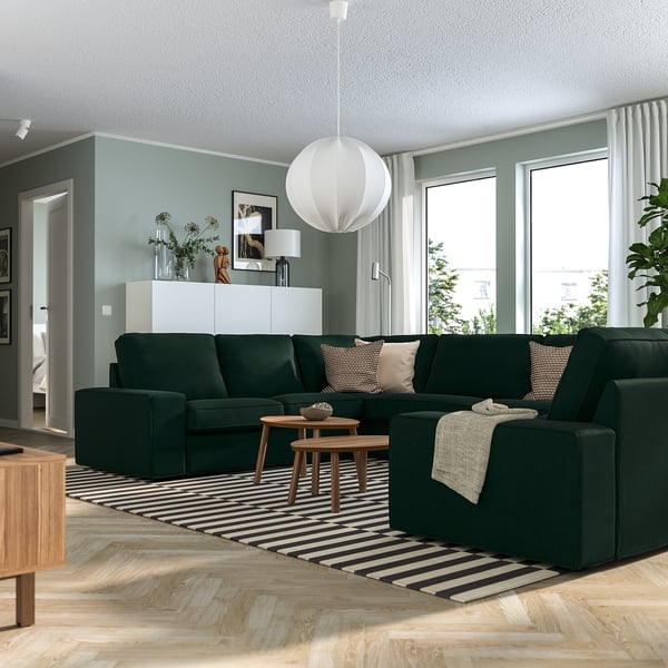 Contemporary living room with KIVIK sofa, cushions, and black-and-white rug. Perfect for relaxing.