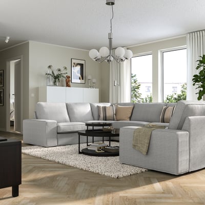 KIVIK grey sofa with 3-seat & chaise, wood floors, large windows, black coffee table.