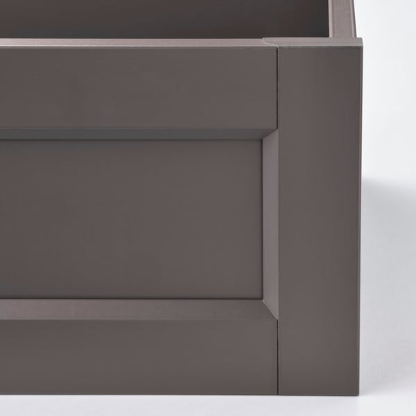 Dark grey modern drawer, part of KOMPLEMENT series. Smooth finish with subtle light reflection, indicating high-quality materials and craftsmanship.