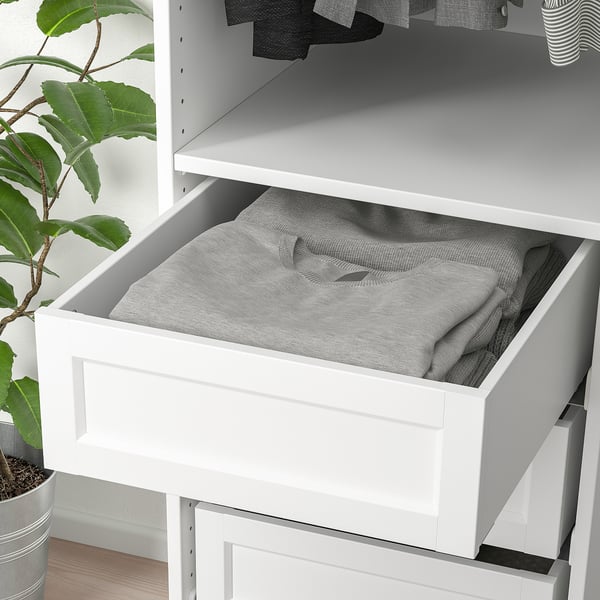 A white drawer with grey fabric inside, part of an organisational system. Its designed for easy storage and access to items like clothes.