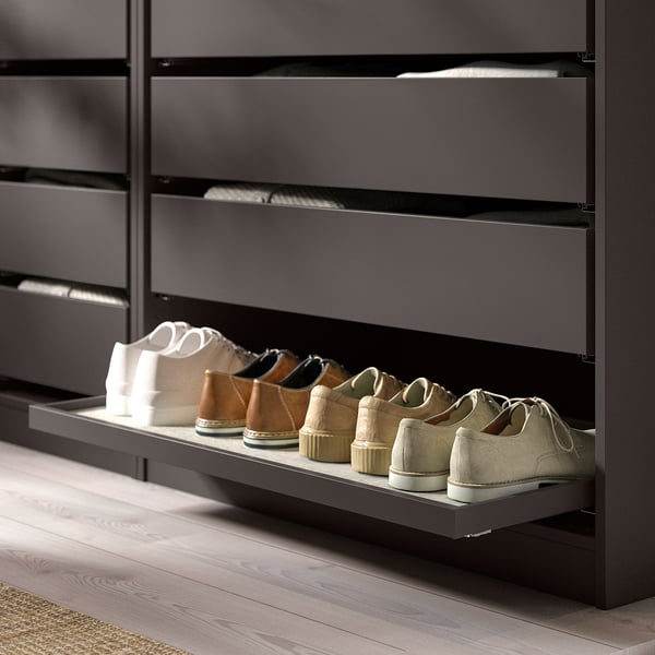 Modern dark grey shoe shelf unit, holding various shoes, in a closet.