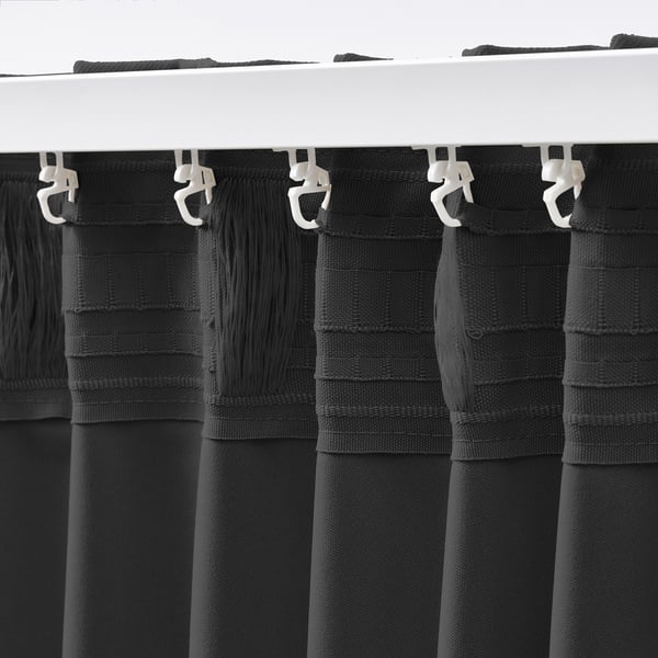 Black block-out curtains hang, ensuring light blockage & privacy.