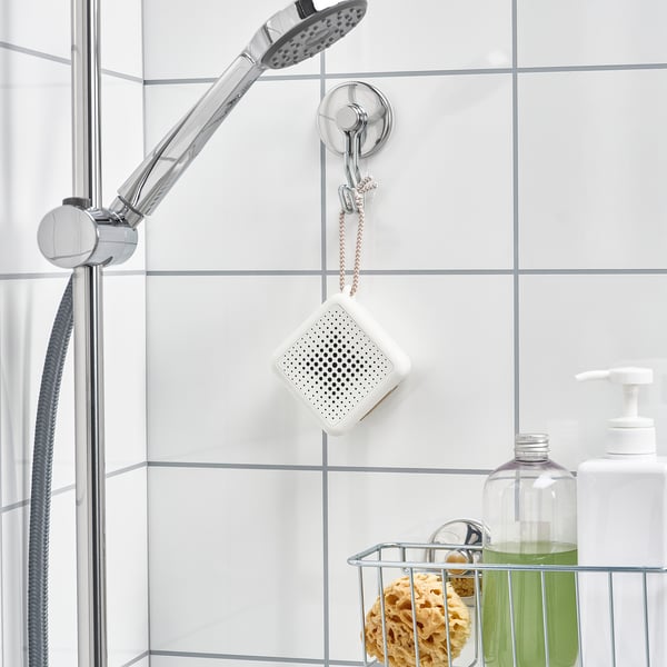 Shower speaker on hook, surrounded by bathroom products.
