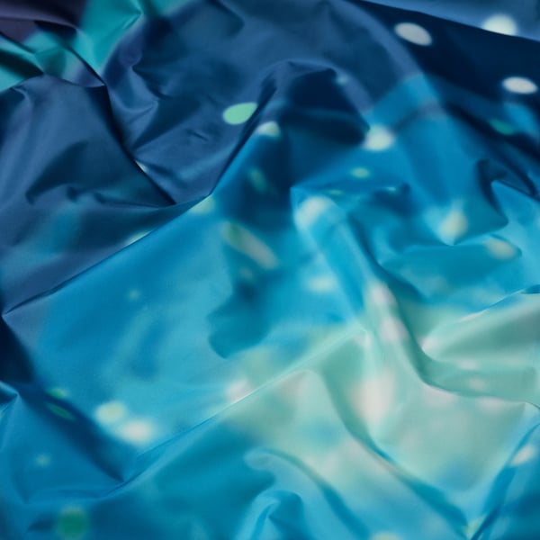 Smooth, shimmering blue space-themed tent fabric with scattered white stars, creating a cosmic atmosphere.