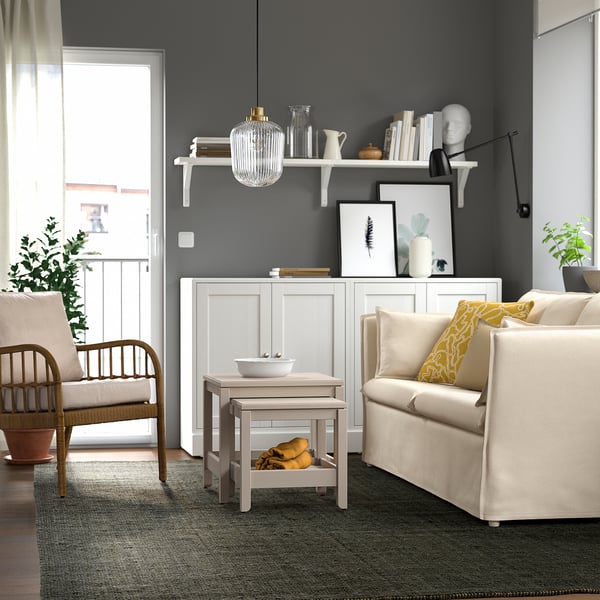 Modern living room with LANDBANA jute rug, grey walls, white furniture, and plants.