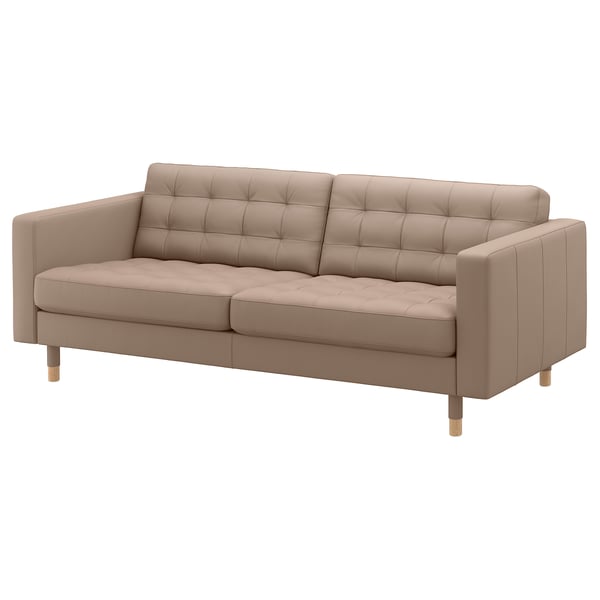 Tan leather sofa, boxy shape, wooden legs, tufted back & seat.