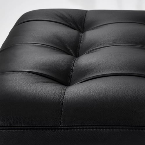 Black leather seat detail, showcasing smooth surface and stitching.