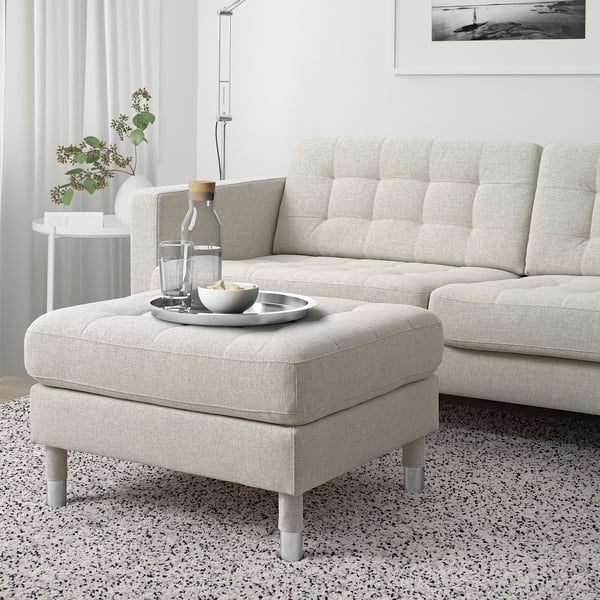 Modern light grey fabric LANDSKRONA footstool, chrome legs. It matches a large sofa, sits next to a vine plant. 10 year guarantee.