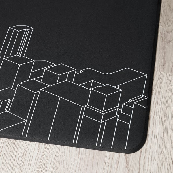 Black gaming chair floor mat with white cityscape design on wooden floor.