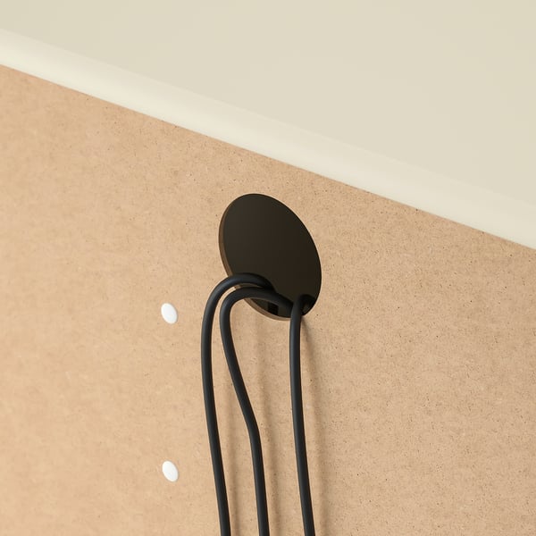 Black cable management clip on beige wall, organising cords.