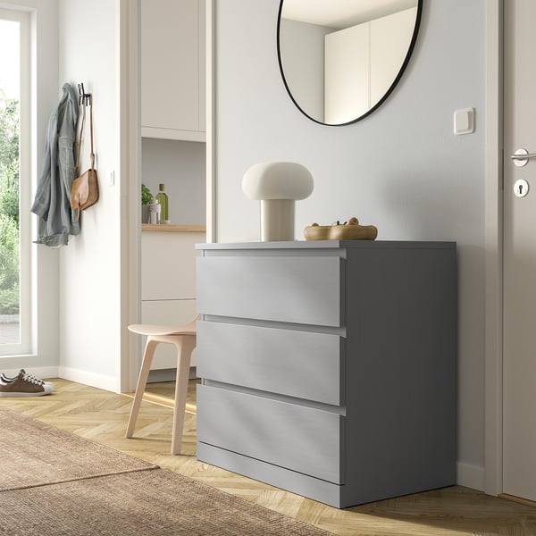 Grey MALM chest in hall with lamp, jacket, bag, chair.