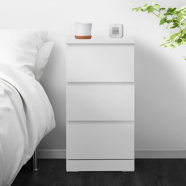 White MALM chest with 3 drawers, clock, and cup.