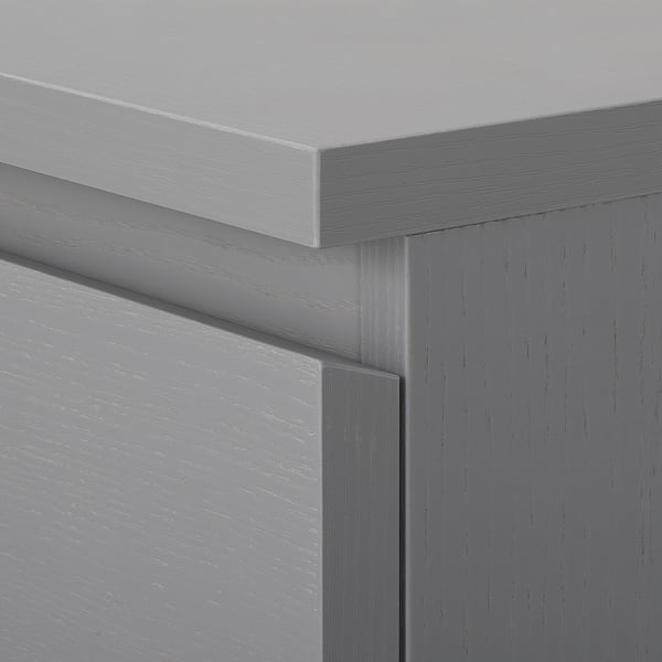 Close-up of grey wooden chest drawers showing smooth edges and well-finished joints.