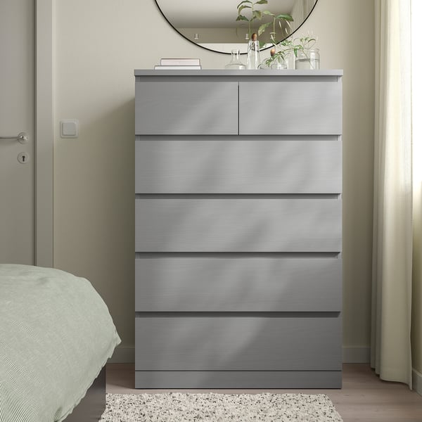 Grey MALM chest in bedroom, six drawers, under mirror.