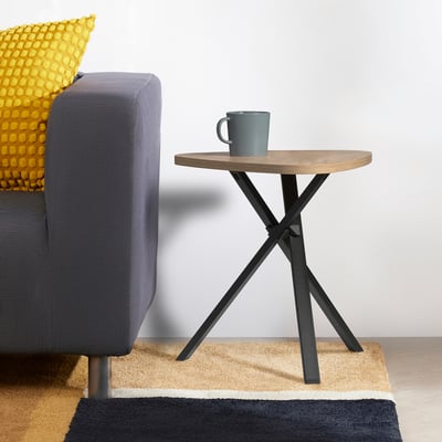 Modern MARIEDAMM side table with light wood top and black legs. Grey mug, sofa with yellow pillow. Compact for small spaces.