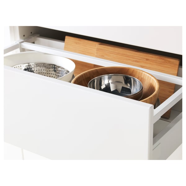 White kitchen drawer fully pulled out; holds metal bowl, wooden bowl, colander, and cutting boards. Soft-close feature.