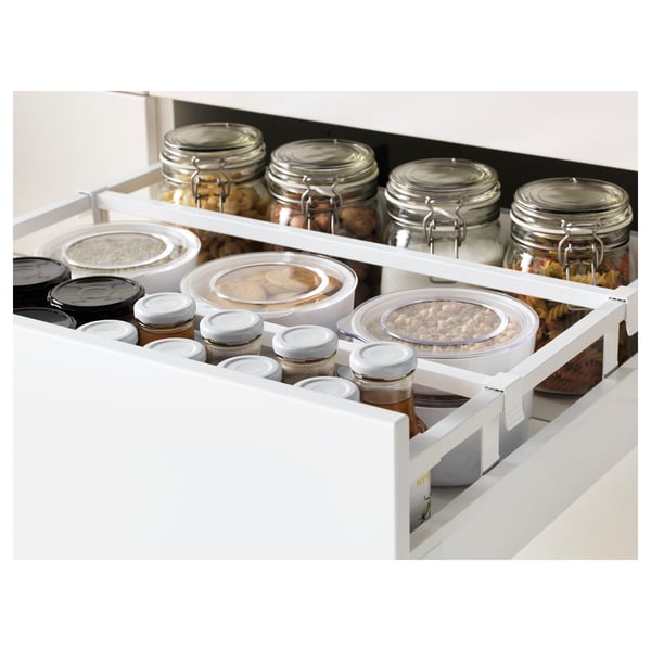 Open kitchen drawer showing organised jars and containers for food storage.