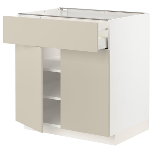 White METOD kitchen unit with beige drawer and shelves.