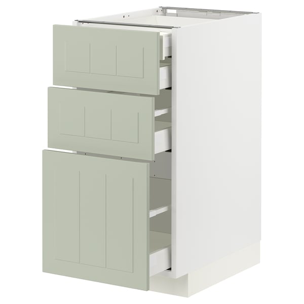 Modern kitchen unit with three green drawers and white cabinet.