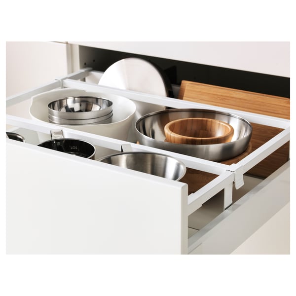 White kitchen drawer with multiple compartments holding pots, pans, and wooden accessories.