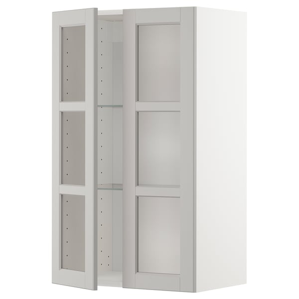 White METOD kitchen cabinet with glass doors, featuring bevelled edges and adjustable shelves.