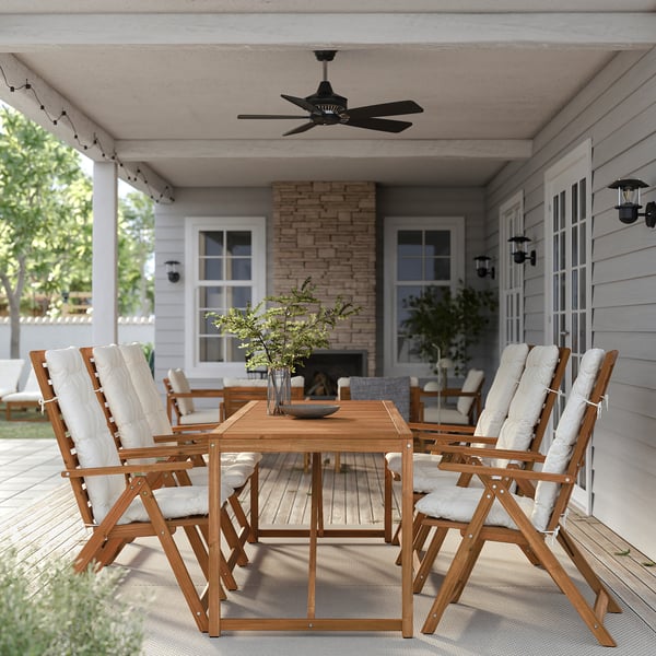 Outdoor patio with NÄMMARÖ wooden chairs and table, white cushions, potted plants and ceiling fan.