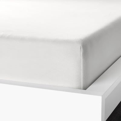 White bed sheet corner displayed, showcasing soft, velvety cotton flannel and elastic edging for secure fit.