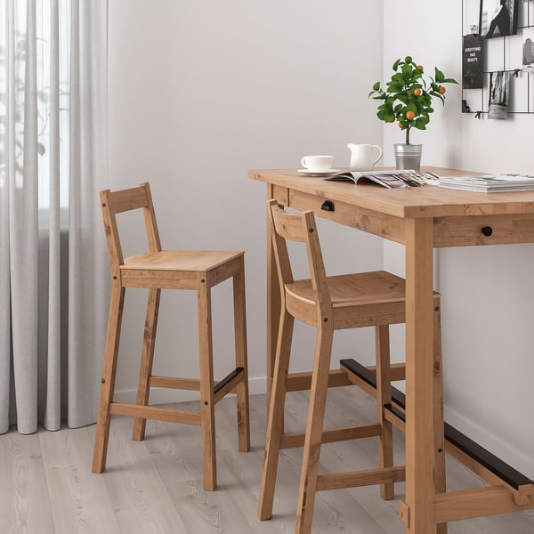 Minimalist bar setup with wooden NORDVIKEN stools & table. Light, curved design.
