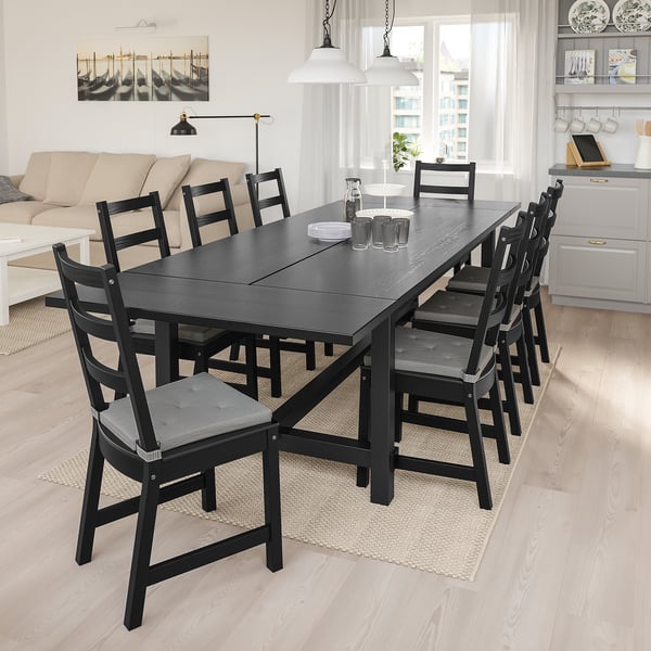 Modern dining set with black NORDVIKEN table & 8 chairs in bright living space.