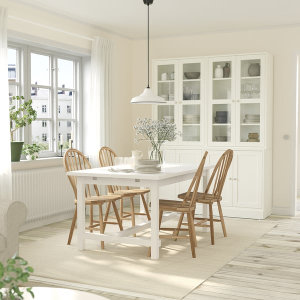 Bright dining room with extendable NORDVIKEN table, chairs, cabinet, light, and window.