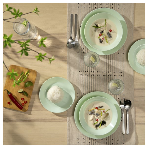 Green glass plates with food, utensils, and decor.