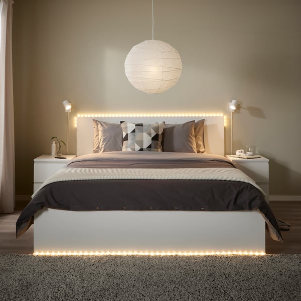 Modern bedroom with led lights, neutral bedding, and wall lamps.