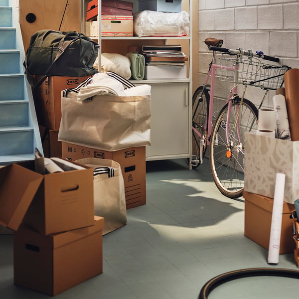 Storage room with boxes, pink bike, white cabinet, PAPPIS box.
