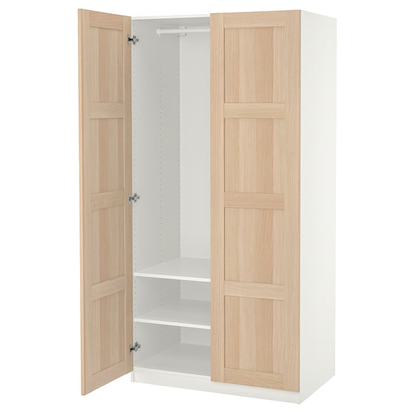 An open ikea PAX wardrobe. Its light beige with wooden panels, a white interior, and two adjustable shelves.