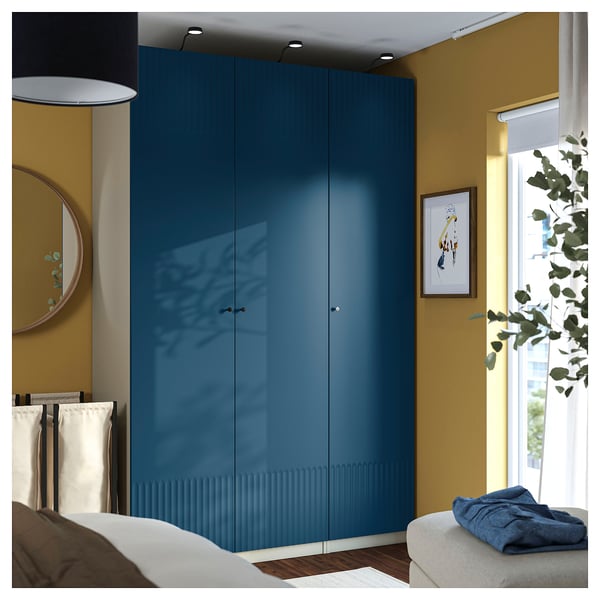 Blue PAX wardrobe in bedroom beside window, with bed and furniture.