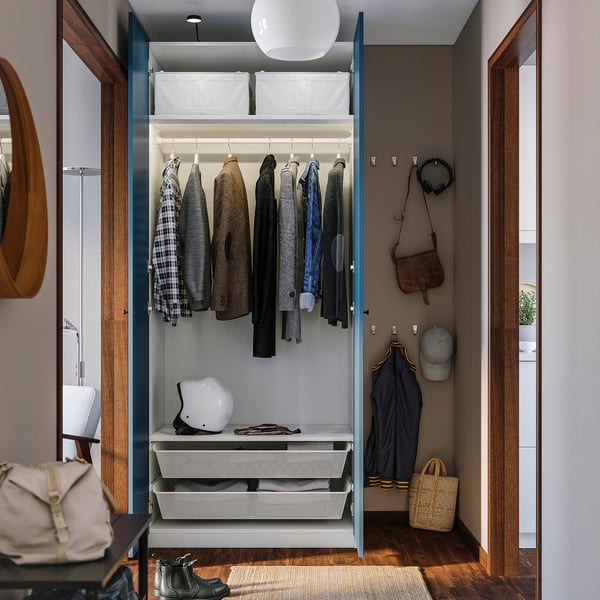 Open wardrobe displaying clothes, helmet, and bags, showcasing organised storage solutions.