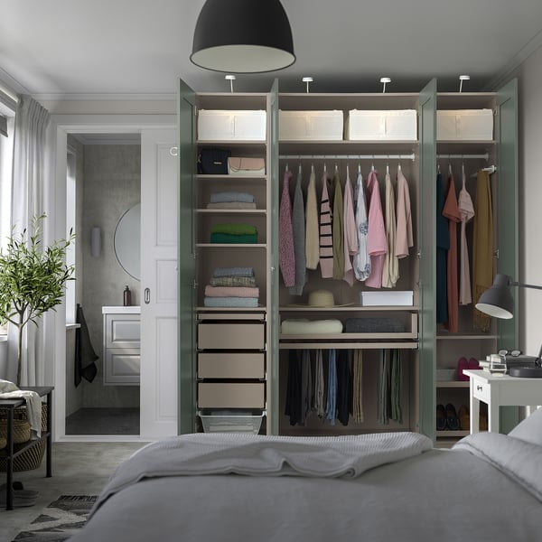 Modern bedroom with PAX wardrobe, clothes, shelves, lighting, bed, and plant.