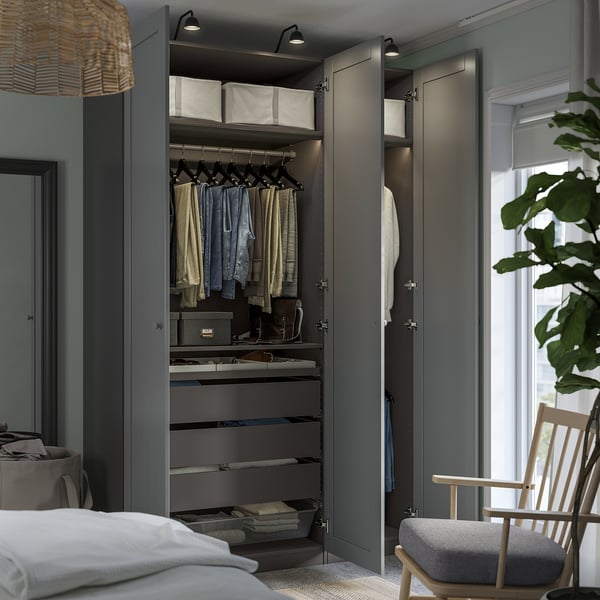 Using an open PAX wardrobe, showing organised clothes, shelves, and storage boxes, highlighting efficient storage and a clean look.