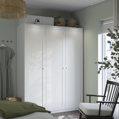 White wardrobe, black chair, green bed, wicker basket, decor.