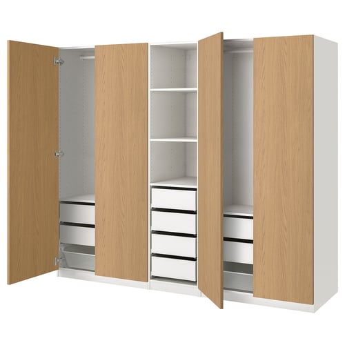 Modern light wood PAX wardrobe shows open drawers and shelves, showcasing organised storage. White and wooden tones.