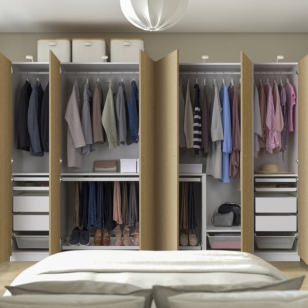 Modern wardrobe with hanging, shelves, and trays behind wooden doors.