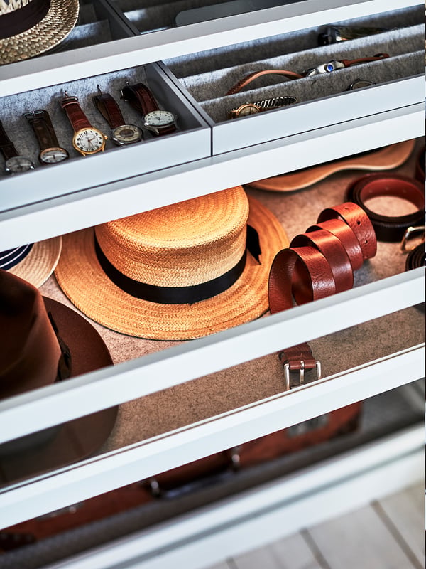 PAX wardrobe organiser: multiple drawers and shelves storing watches, belts, and hats; grey, white, brown, rectangular, modern design.