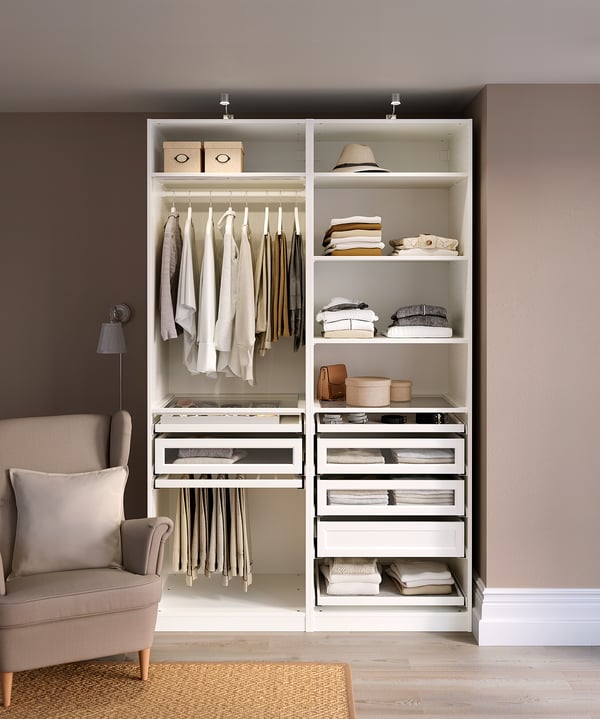 A modern, white PAX wardrobe with shelves, drawers, and hanging space for clothes.