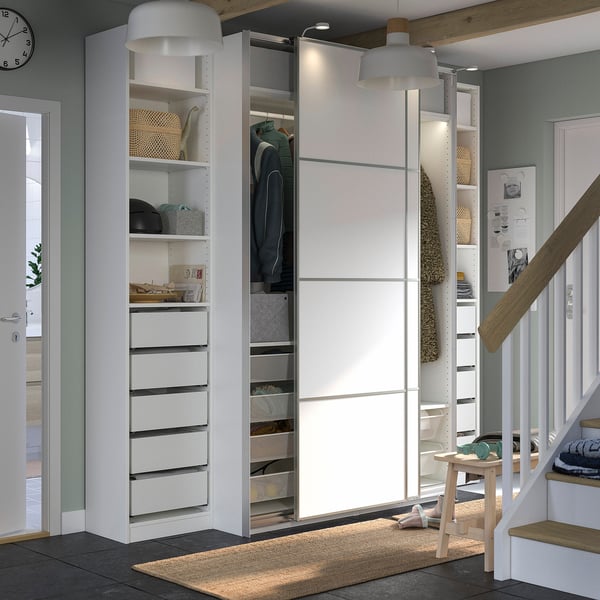 White PAX wardrobe with shelves, drawers, lights, and stool.