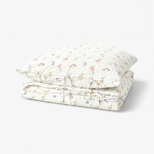 Folded white duvet set with small floral prints and seersucker texture. Made from cotton and viscose blend.