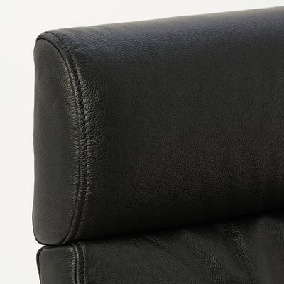 Kaynak: high-quality black leather headrest on a cushioned chair, showcasing smooth texture and neat stitching.
