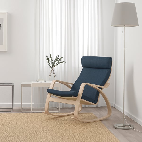 Modern living room with POÄNG blue rocking chair, curtains, lamp, table, decor.