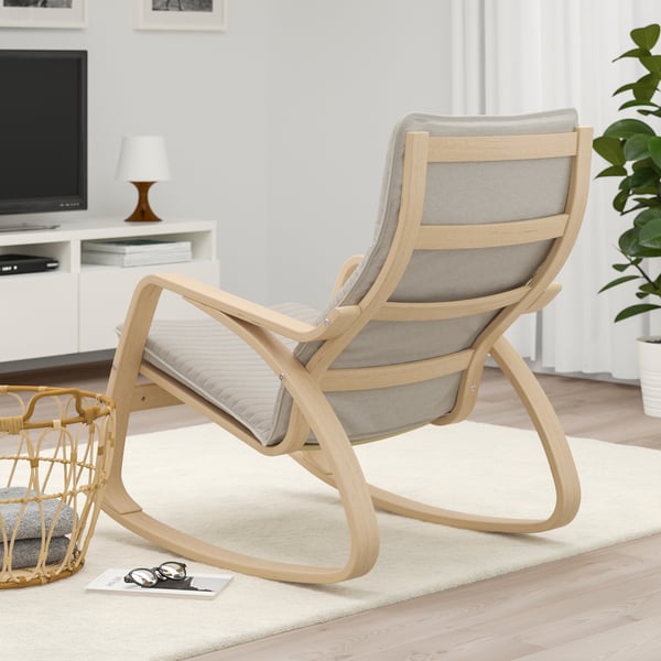 Wooden rocking chair with cushioned seat and back in light, airy living room.