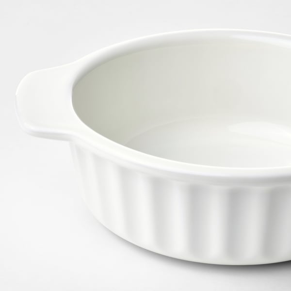 Small, round white oven dish with handles. Clean, ribbed design. Ideal for pies or vegetables.