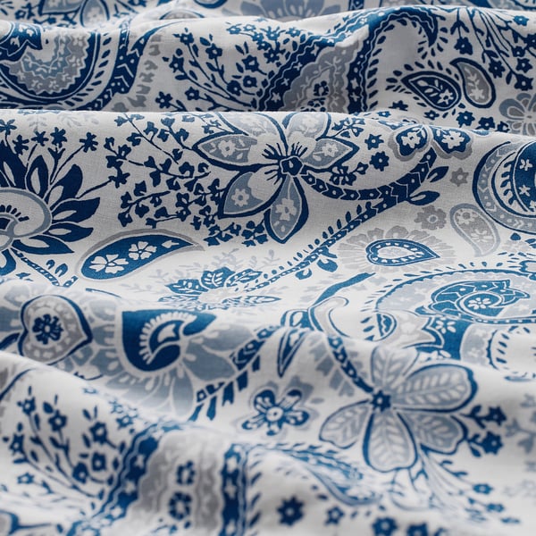 Close-up of soft, intricately patterned fabric with blue paisley designs on white cotton-viscose blend.